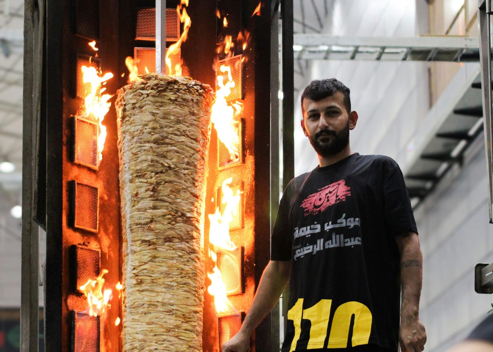 A man standing in front of a burning object